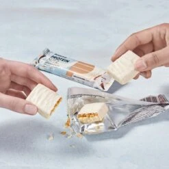 PowerBar Eiweissriegel Protein Nut2 Weiße Schokolade/Karamell-Kokosschicht 12x45g Box -Head || Wilson || YONEX Verkäufe Powerbar 21614101 Protein Nut2 Riegel 3 1185x1185 1